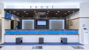 A reception area with a 'FRONT' sign, a digital display, and a blue reception desk. - Toyoko Inn Sodegaura-eki Kita-guchi (Sodegaura)
