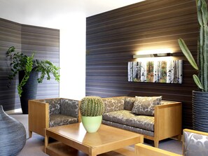 A modern living room with a sofa, a coffee table, and a cactus centerpiece.