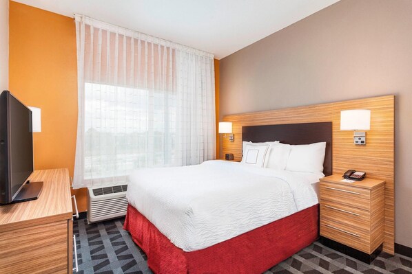 A hotel room with a bed, bedside tables, a TV, and a window with curtains. - Towneplace Suites by Marriott Orlando Altamonte Springs/maitland (Altamonte Springs)