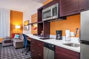 A compact hotel room with a kitchenette, a sofa, a coffee maker, and a built-in dishwasher. - Towneplace Suites by Marriott Orlando Altamonte Springs/maitland (Altamonte Springs)