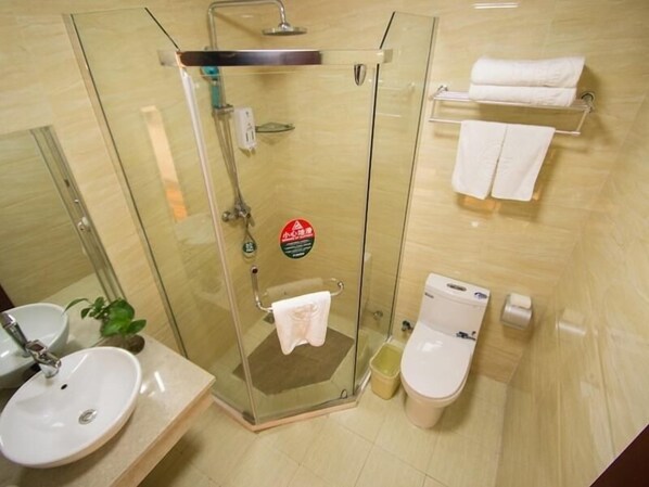 Een badkamer met een douchecabine van glas, een wastafel, een toilet en een handdoekhouder.