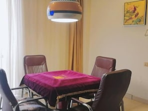 A dining area with a table covered by a purple cloth, surrounded by four leather chairs. - Greentree Inn Wuhu Fangte Forth Phase Wanchun Fortune Plaza Business Hotel (Wuhu)