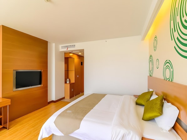 A modern hotel room with a large bed, a TV mounted on the wall, and a wooden wardrobe. - Greentree Inn Wuhu Fangte Forth Phase Wanchun Fortune Plaza Business Hotel (Wuhu)