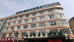 A multi-story hotel with a curved facade, multiple windows, and a sign indicating it is a hotel.