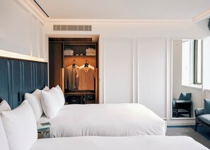 A hotel room with a large bed, a walk-in closet, a seating area, and a window. - Page8, Page Hotels (London)