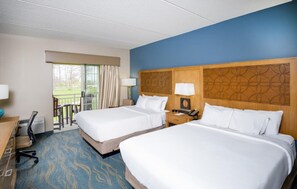 Een hotelkamer met twee bedden, een bureau, een stoel, een lamp en uitzicht op de omgeving.