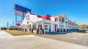 A hotel with a red roof, multiple balconies, and a sign indicating the exit. - Hotel Waco University Area/ I-35 (Waco)