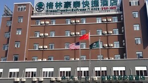 Un hotel de varios pisos con un letrero destacado que muestra caracteres chinos.