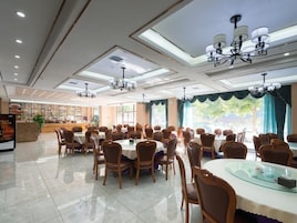 Un comedor amplio con varias mesas y sillas, una recepción y un expositor de menú.