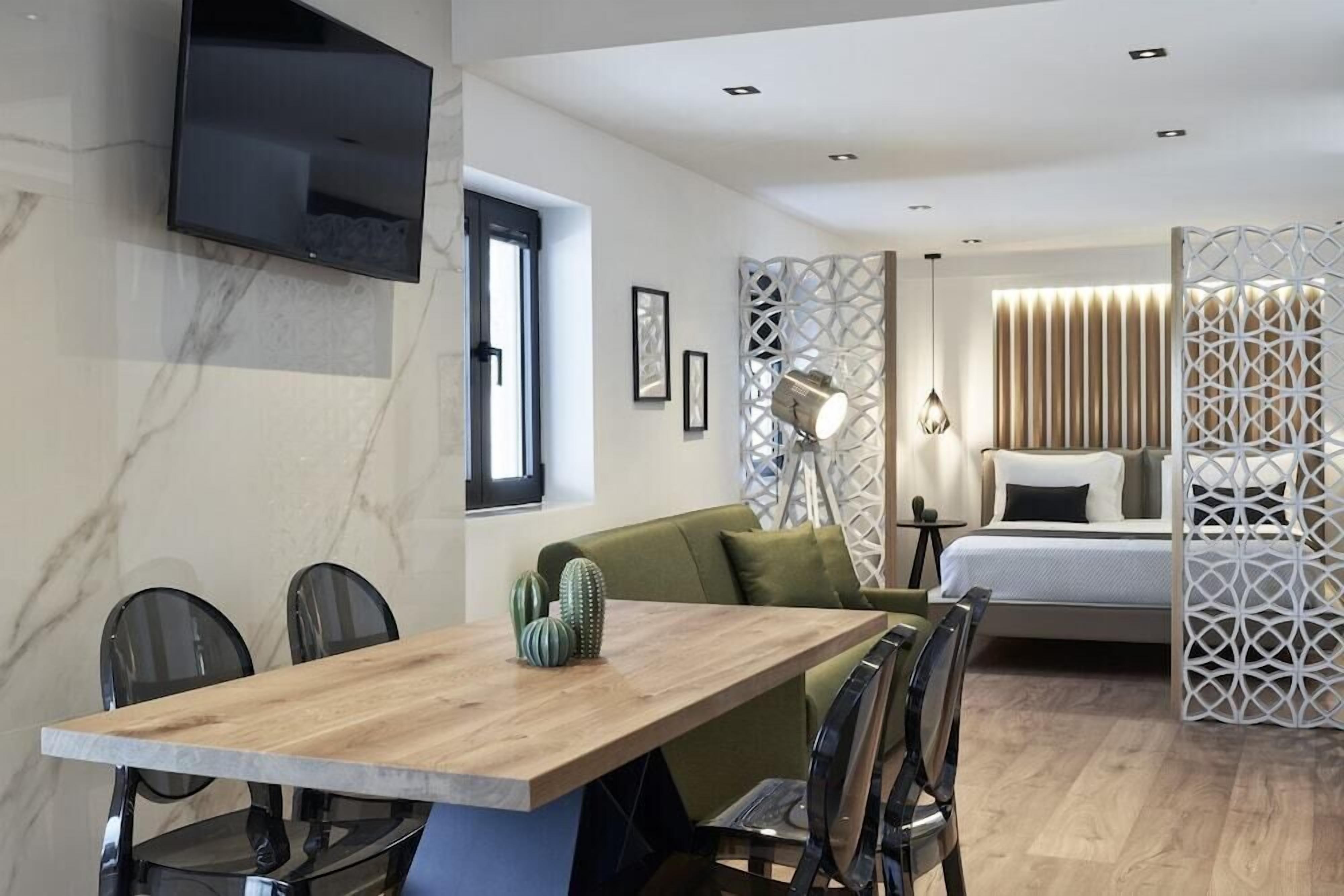 Un interior moderno con una mesa de comedor de madera, sillas, un sofá, una cama y elementos decorativos.
