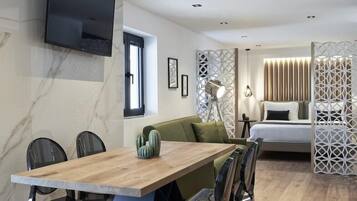 Un interior moderno con una mesa de comedor de madera, sillas, un sofá, una cama y elementos decorativos.
