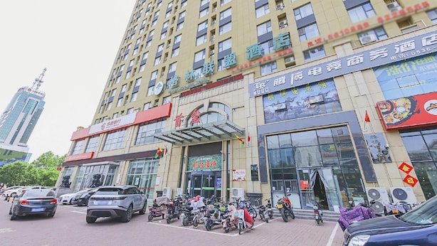 A multi-story hotel with a prominent entrance and several shops on the ground floor. - Greentree Alliance Weifang Shouguang Square Street Guhuai Road Hotel (Weifang)