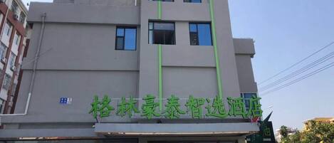 Un edificio con fachada moderna, varios ventanales y un letrero que indica que es un hotel.