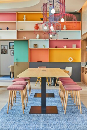 Un espace repas moderne avec une table en bois, des chaises assorties et un tapis bleu.