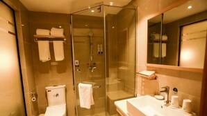 Une salle de bain moderne avec une douche à parois de verre, des toilettes et un lavabo équipé de produits de toilette.