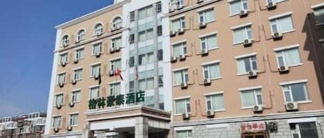 Un hôtel à plusieurs étages, doté d’une entrée principale, de nombreuses fenêtres et d’un drapeau au sommet.