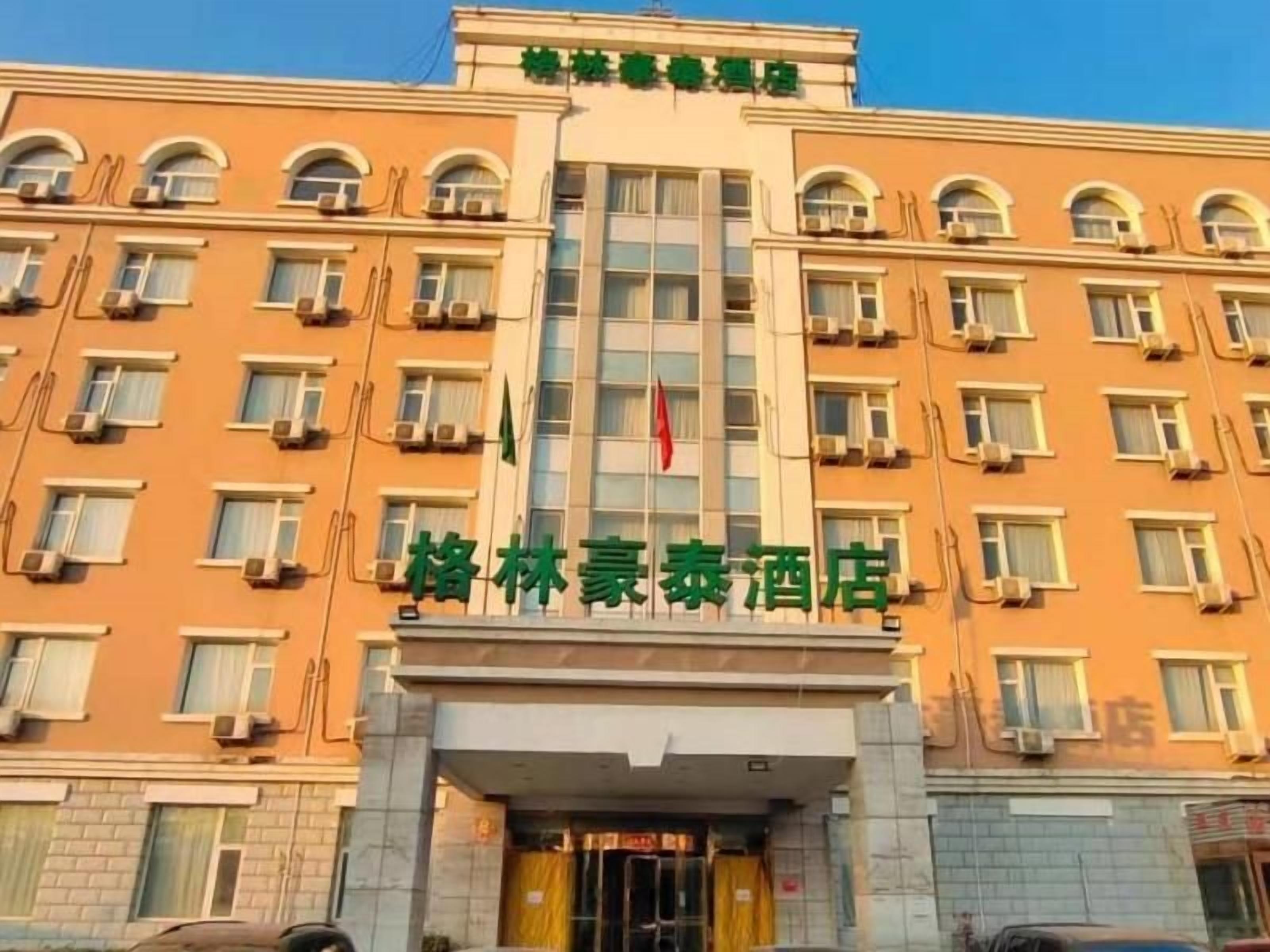 Un edificio de hotel de varios pisos con una entrada destacada y una bandera.