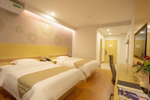A hotel room with two beds, a wooden headboard, a desk with a chair, and a mirror. - Greentree Inn Chizhou Shitai County Zhengwu New District (Chizhou)
