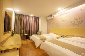 A hotel room with two beds, a desk, a chair, a small table with a plant, and a mirror. - Greentree Inn Chizhou Shitai County Zhengwu New District (Chizhou)