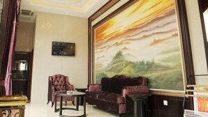 A spacious lobby with a large painting of a sunset, plush seating, and a chandelier. - Greentree Inn Hefei Feixi West People Road Guanyi Road Express Hotel (Hefei)