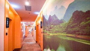 A hotel corridor with a long hallway, doors with room numbers, and a mural of a mountainous landscape with a lake. - Greentree Inn Hefei Fuyang Bei Road Beicheng Shuangfeng Industrial Park (Hefei)