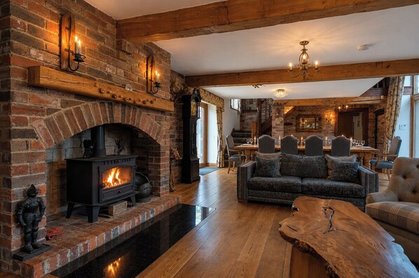 A cozy living room with a brick fireplace, a wooden coffee table, and a sofa. - The Residence - Sleeps 10, 2 Hot Tubs near Durham & Bishop Auckland (Oakenshaw)