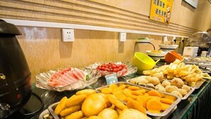 A buffet with various food items including sliced meats, fruits, and fried snacks. - Greentree Inn Jiangsu Xuzhou Peixian Bus Station Tangmu Road Business Hotel (Xuzhou)