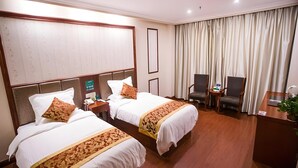 A hotel room with two beds, a desk, two chairs, a plant, and a large window with curtains. - Greentree Inn Jiangsu Xuzhou Peixian Bus Station Tangmu Road Business Hotel (Xuzhou)