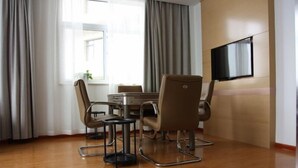 Un comedor moderno con piso de madera, una mesa redonda y cuatro sillas.