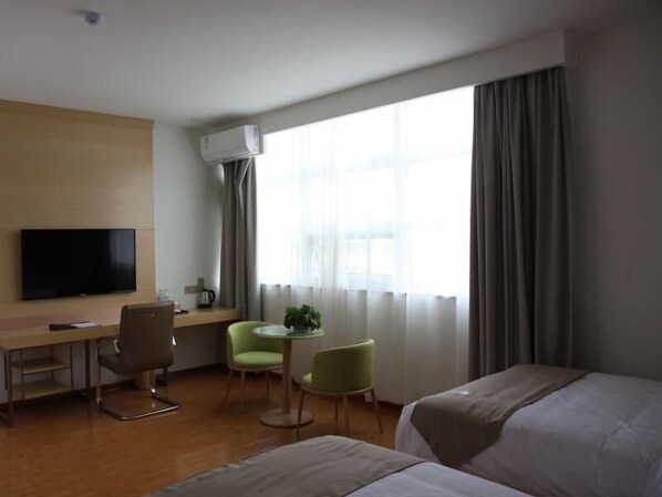 A hotel room with a bed, a desk, a chair, a TV, and a window with curtains. - Greentree Inn Zaozhuang High-speed Train Station Express Hotel (Zaozhuang)