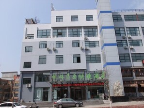 A multi-story building with a modern architectural design, featuring a prominent entrance with signage.