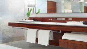 A modern bathroom with a wooden vanity, a large mirror, and a towel rack. - Las Alcobas A Luxury Collection Hotel Mexico City (Mexico City)