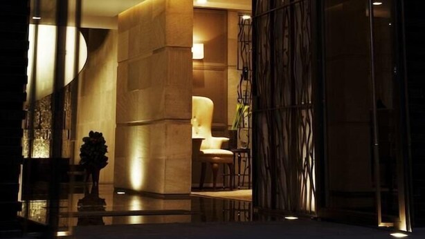 The entrance of 'Las alcobas' hotel with a modern design, featuring a glass facade and a well-lit interior. - Las Alcobas A Luxury Collection Hotel Mexico City (Mexico City)