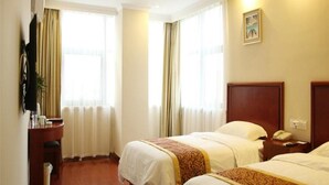 A hotel room with two beds, a desk, and a chair.