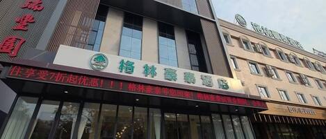 A hotel with a modern facade, large glass windows, and a prominent signage.
