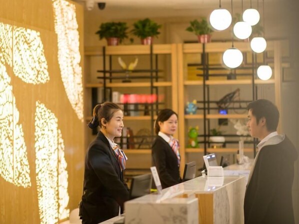 A reception area with a wooden wall, a reception desk, and a counter. - Greentree Inn Puyang Ruifengyuan Business Hotel (Puyang)