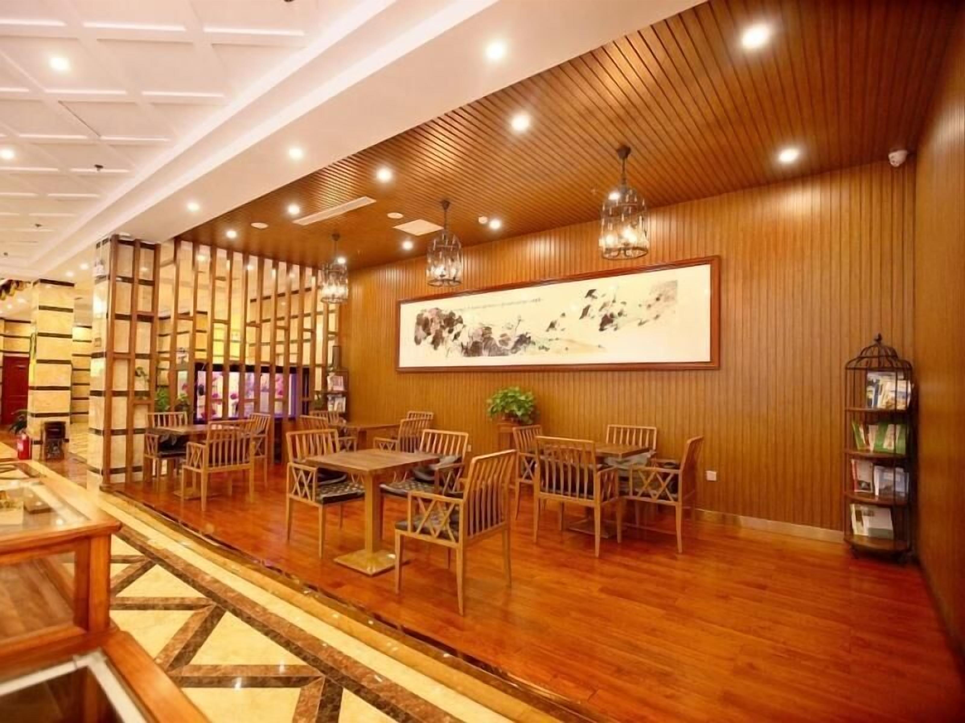 A restaurant with wooden panel walls, a large painting, and multiple tables and chairs.