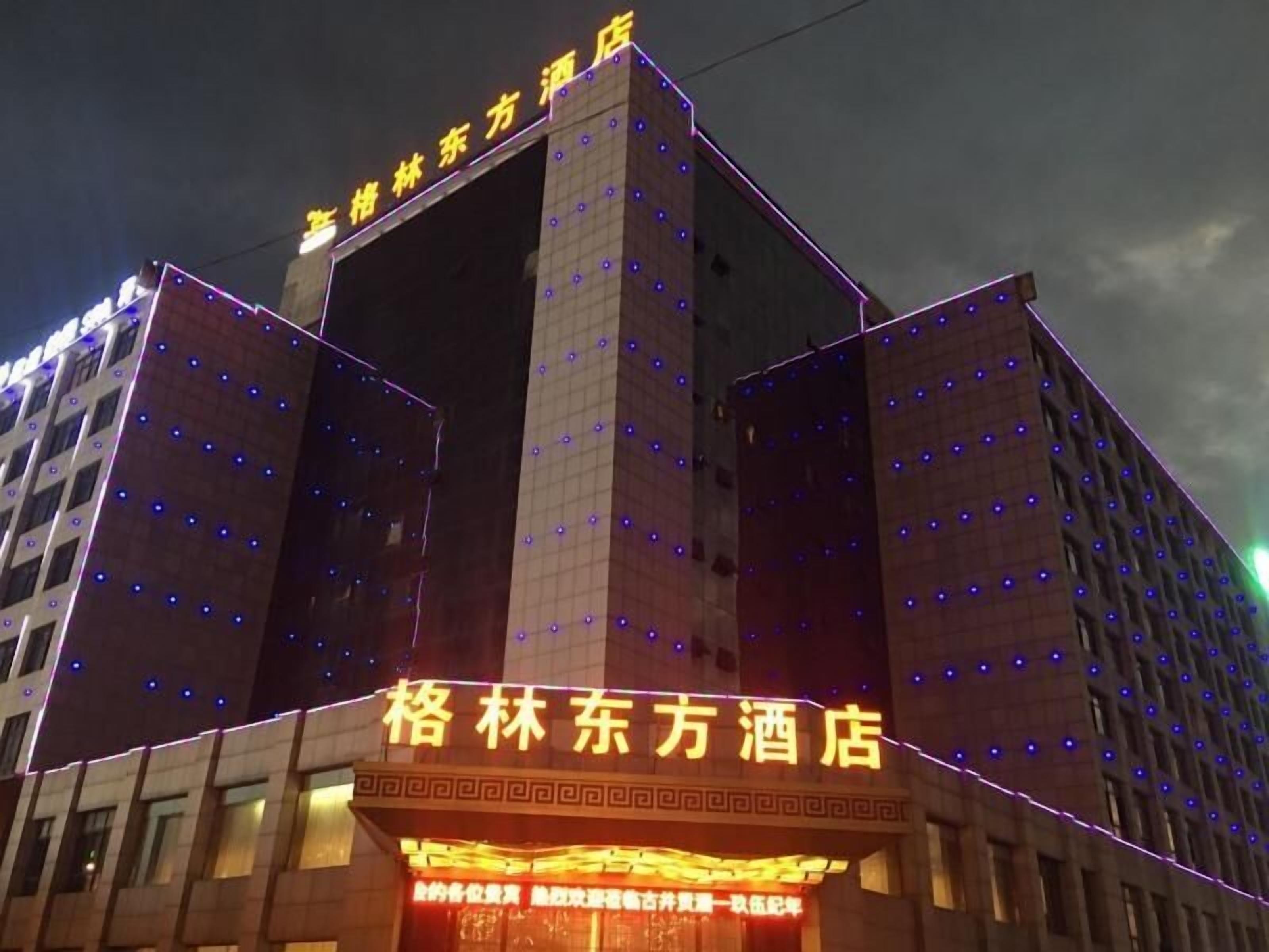 Un hôtel avec une enseigne bien visible et des fenêtres illuminées.