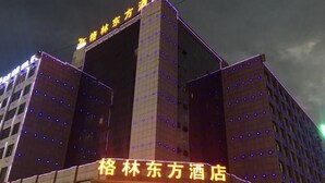 A hotel with a prominent sign and illuminated windows. - Greentree Eastern Bozhou Jingwan Wealth Centre Hotel (Bozhou)