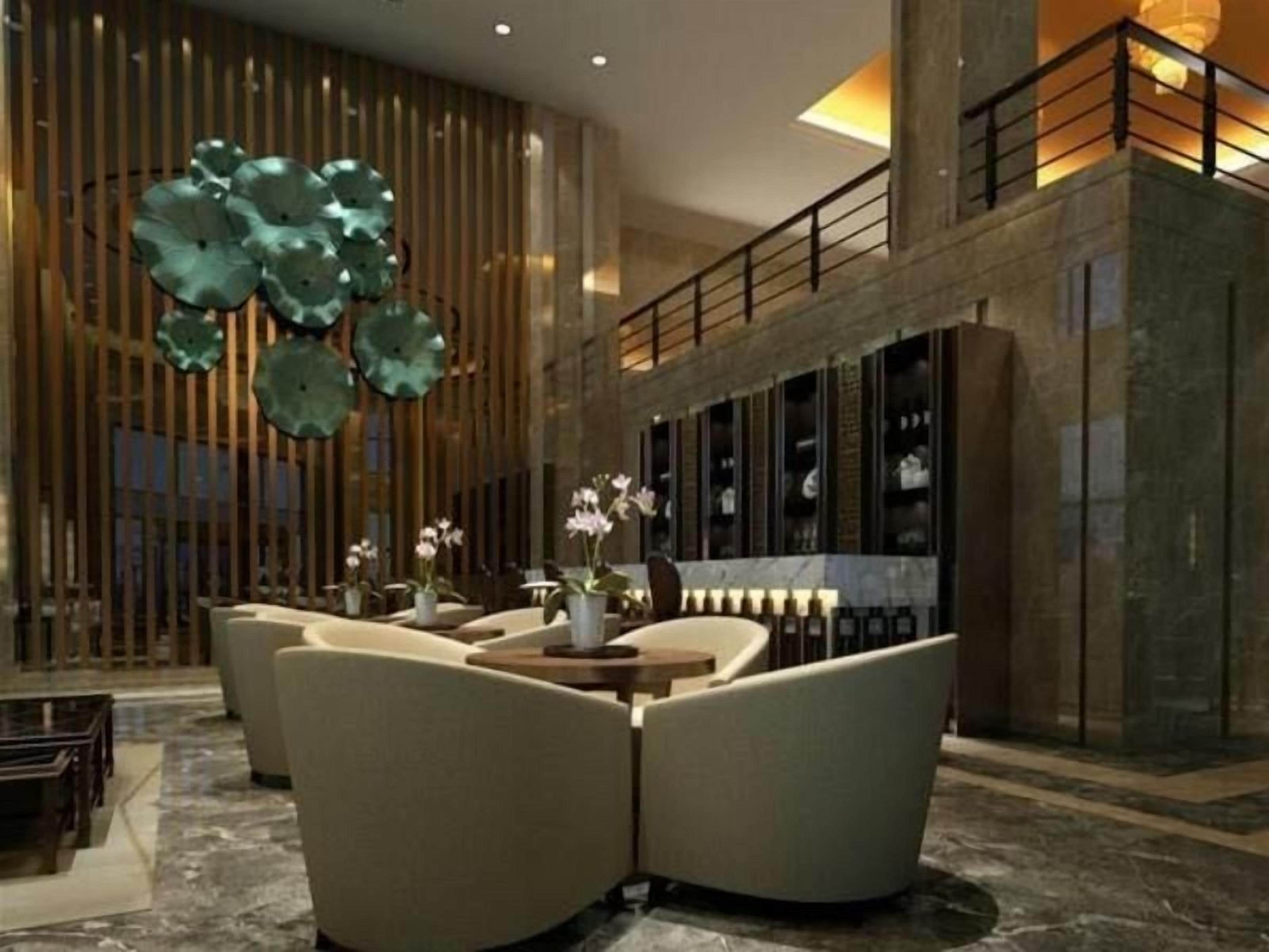 Un vestíbulo moderno con zona de estar, un muro decorativo y una escalera.