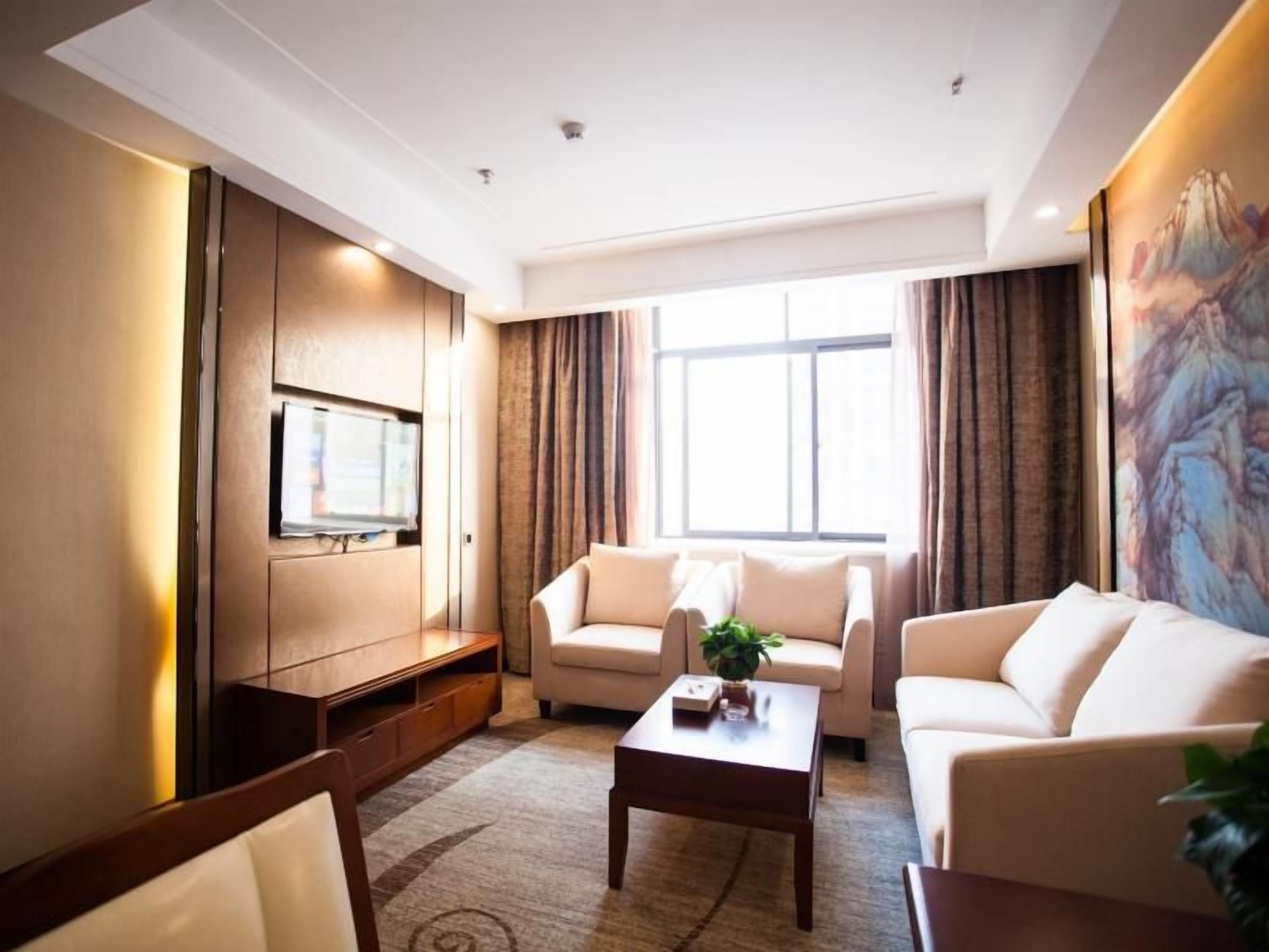 A modern living room with a sofa set, a coffee table, and a flat-screen TV mounted on the wall.