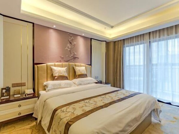 Une chambre d’hôtel moderne avec un grand lit, une table de chevet, une commode et un élément décoratif mural.