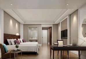 Une chambre d’hôtel moderne équipée d’un lit, d’une table de chevet, d’une lampe, d’une télévision et d’un bureau avec une chaise.