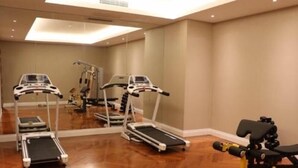 Un gimnasio con cintas de correr y una bicicleta estática.