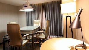 Une chambre d’hôtel équipée d’une table à manger, de chaises, d’une lampe et d’un ventilateur de plafond.