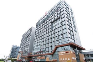 Un hotel a più piani con una moderna facciata in vetro, caratterizzato da una segnaletica ben visibile in cima.