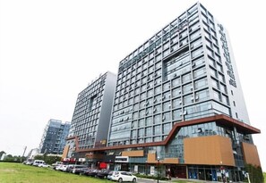En moderne, høj bygning med flere etager, store vinduer og en erhvervspræget stueetage.