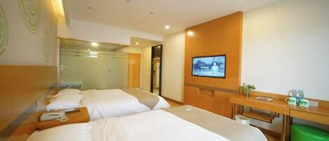 A hotel room with two beds, a desk, a chair, a television, and a green trash bin.