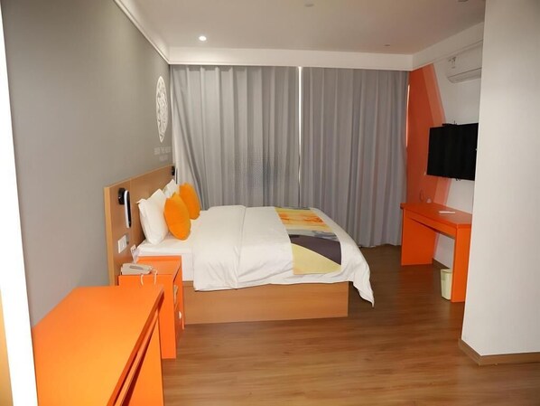 Una habitación de hotel con una cama, un escritorio y un televisor.
