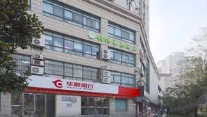 Un immeuble à plusieurs étages, avec une enseigne de la banque Huaxia au rez-de-chaussée.